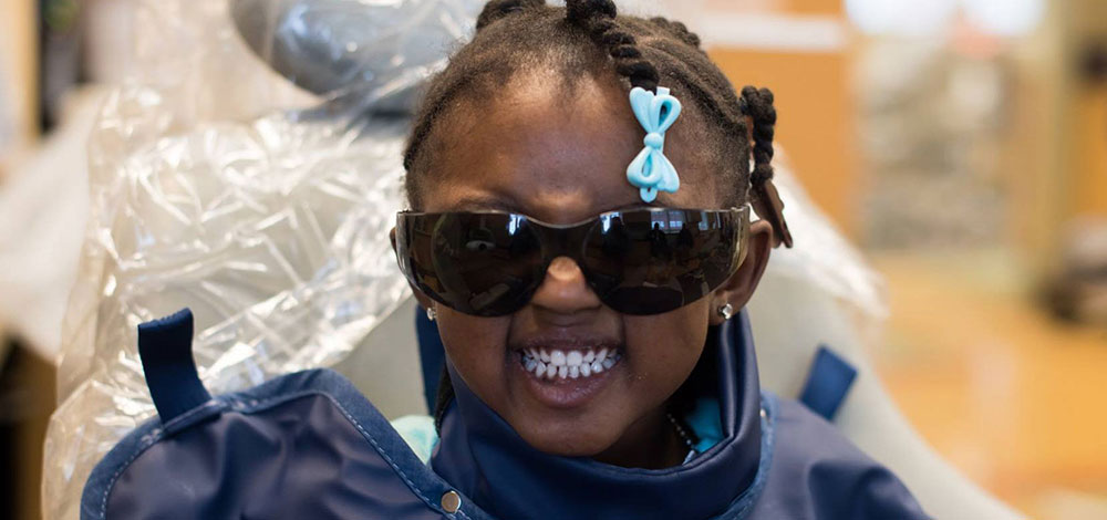 Young girl with sunglasses in dental chair