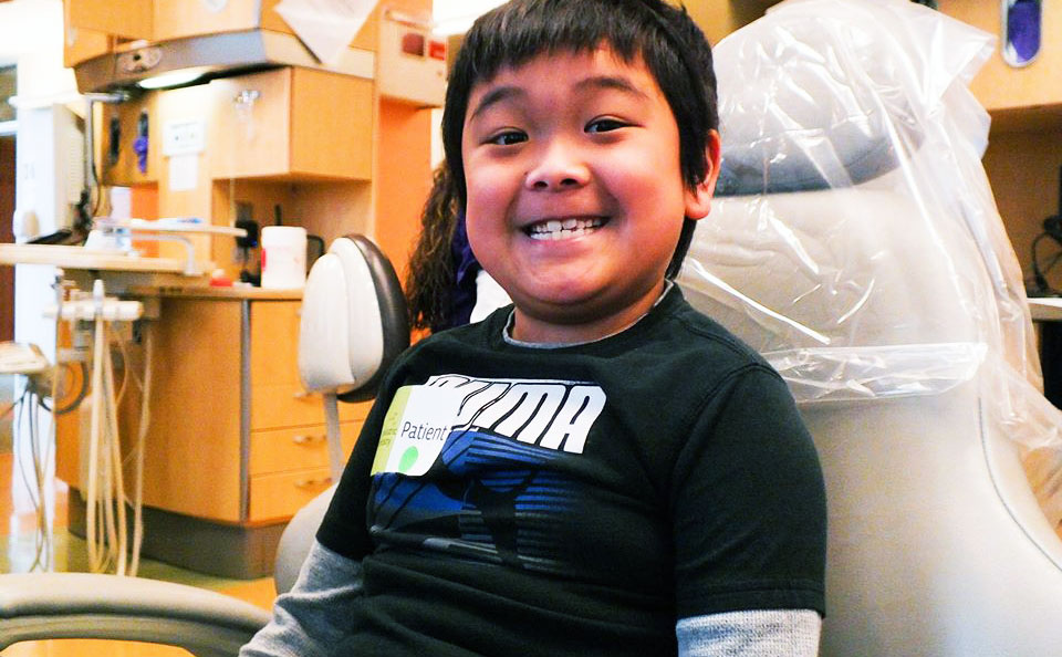 Young boy in dental chair with big smile